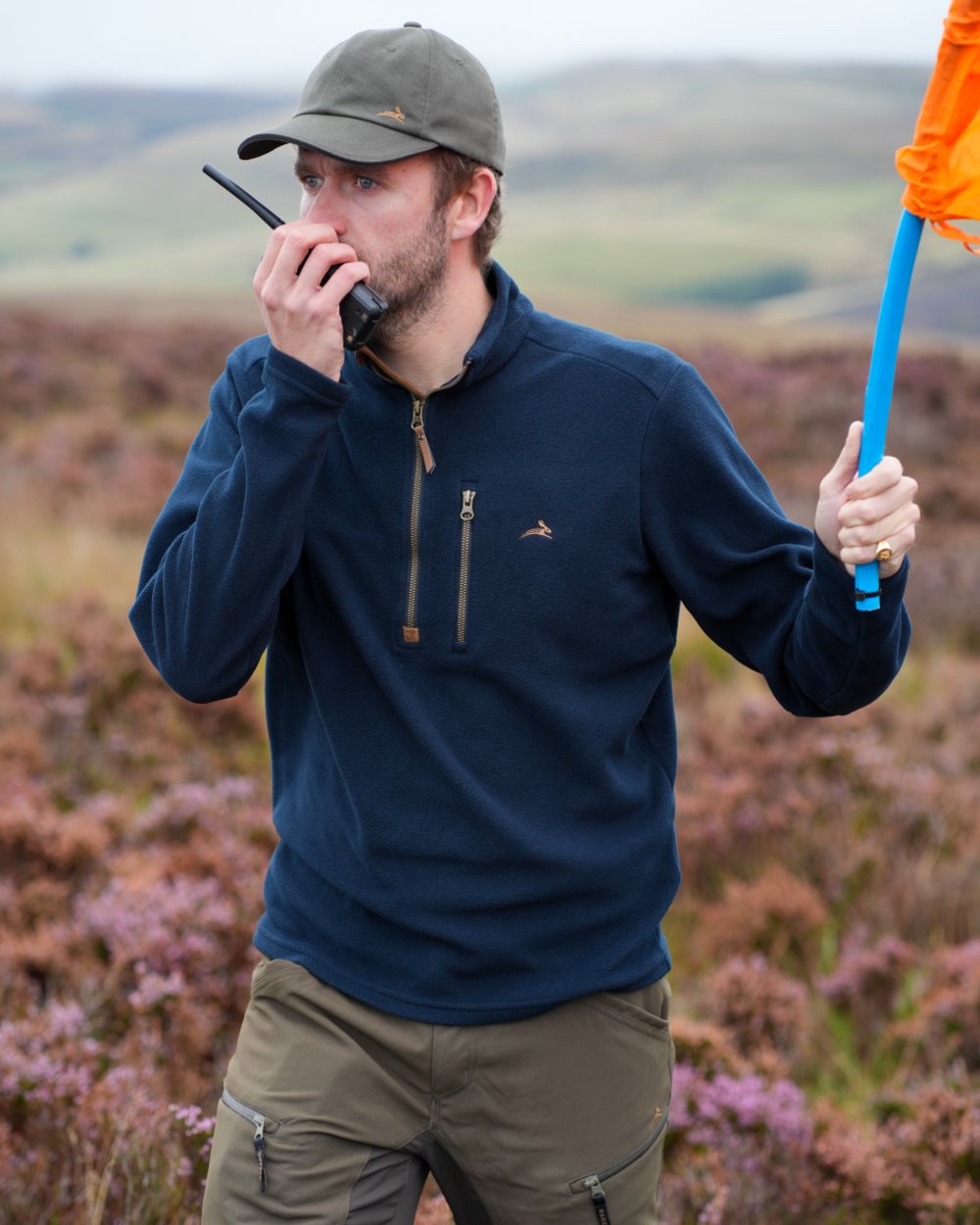 Model wearing a navy coloured Harehill Varden Quarter Zip Fleece on a moorland background 
