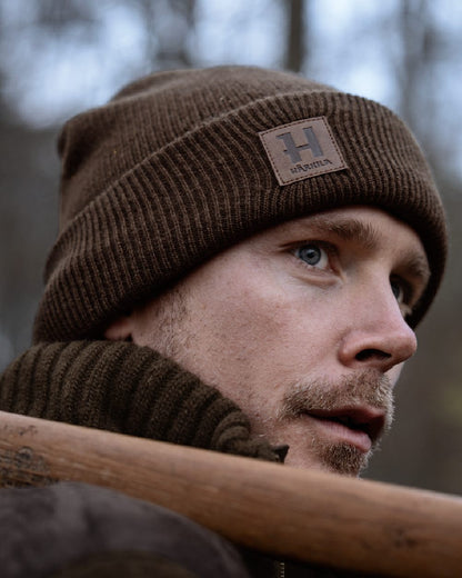 Demitasse brown coloured Harkila Annaboda WSP Knit Beanie on forest background 