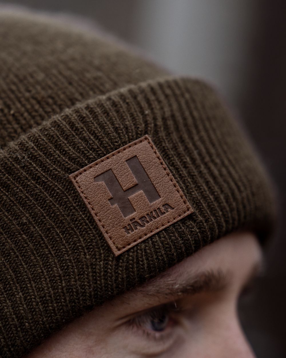 Demitasse brown coloured Harkila Annaboda WSP Knit Beanie on forest background 
