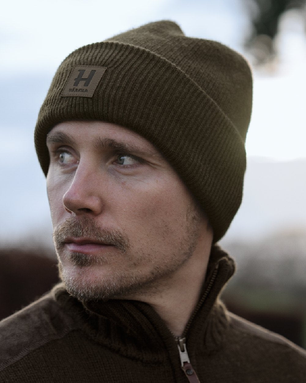 Willow Green coloured Harkila Annaboda WSP Knit Beanie on forest background 