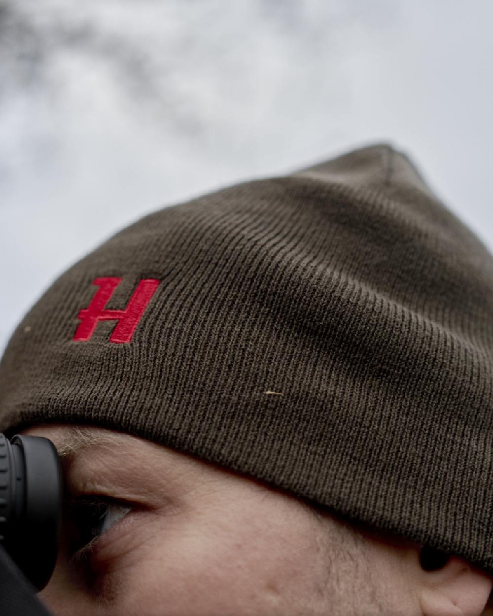Shadow Brown Red Coloured Harkila Aspire Reversible Beanie on outdoor background 