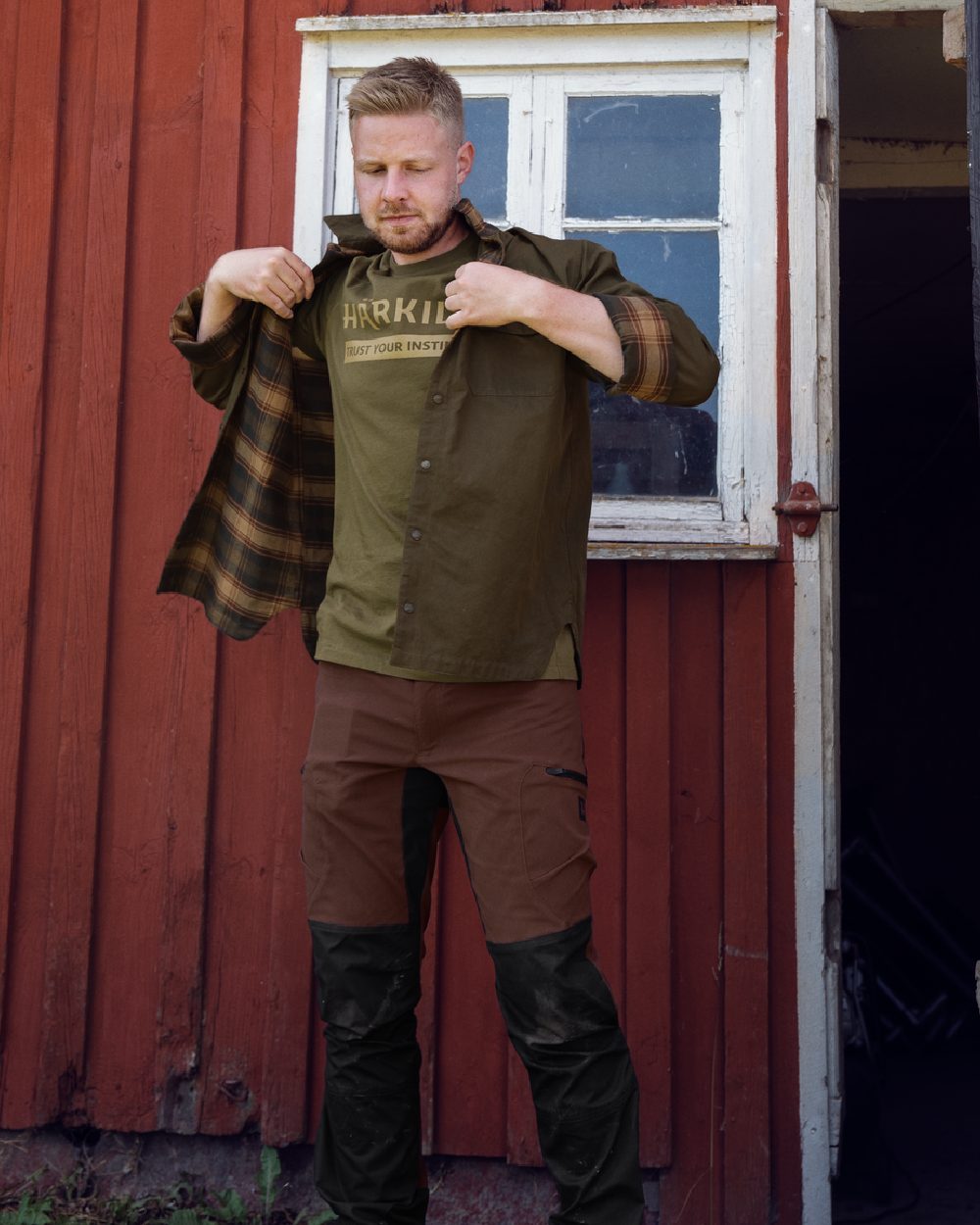 Dark Warm Olive Burgundy Coloured Harkila Eirik Reversible Shirt Jacket on countryside background 