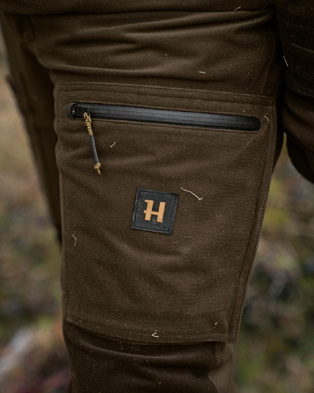 Hunting Green Shadow Brown Coloured Harkila Forest Hunter GTX Trousers on blurry background 