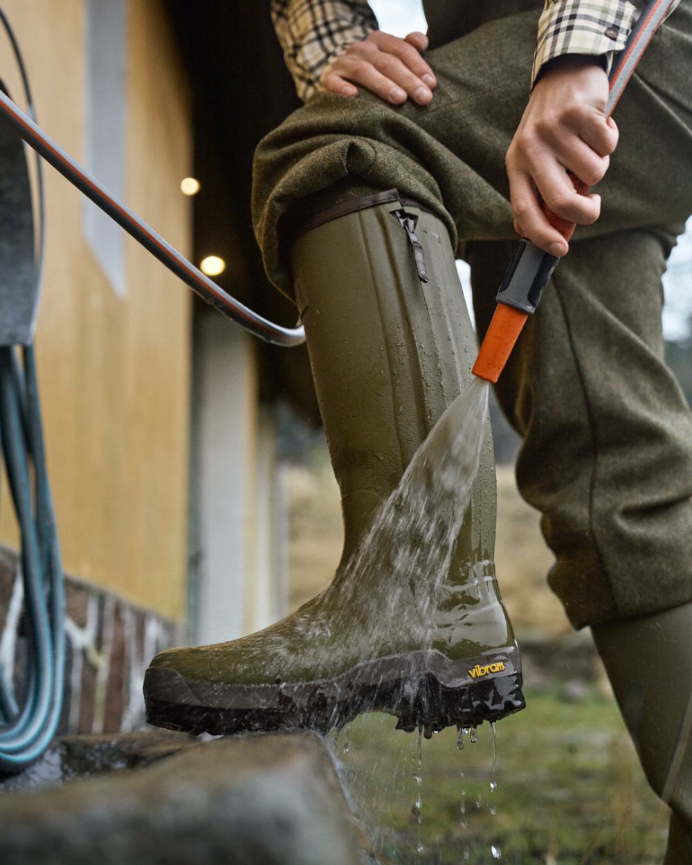 Dark Olive Coloured Harkila Forester Zip Rubber Boot on outdoor background 