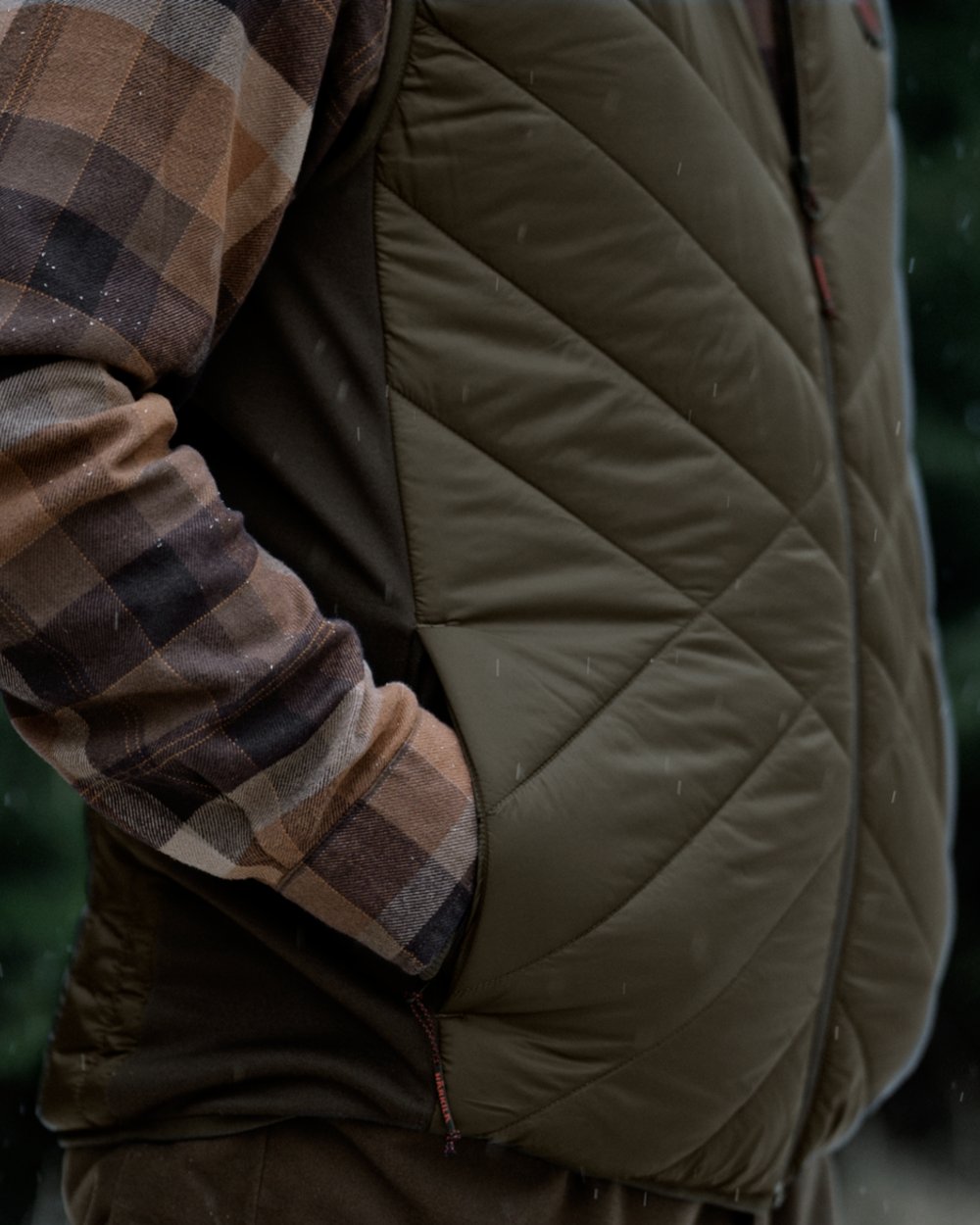 Willow Green Shadow Brown Coloured Harkila Heat Insulated Waistcoat on Forest Background 