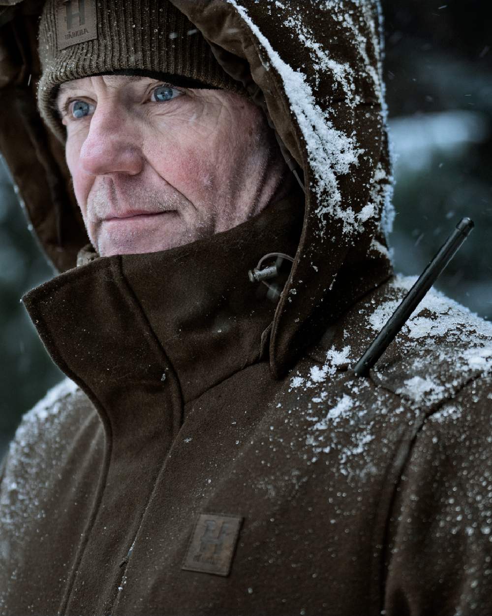 Dark Hunting Green Shadow Brown coloured Harkila Kodiak CleverWool HSP Insulated Jacket on snowy background 