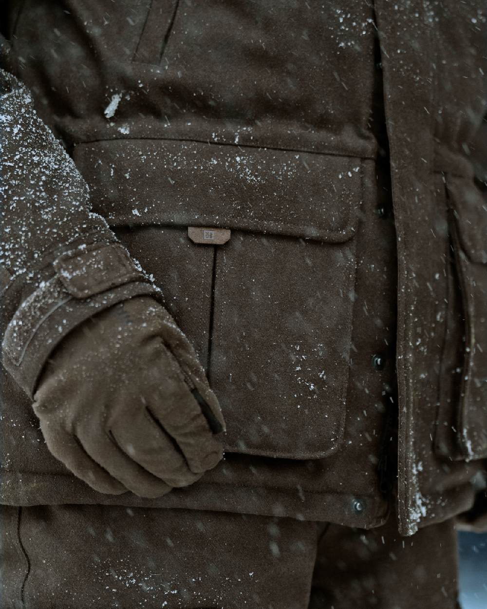 Dark Hunting Green Shadow Brown coloured Harkila Kodiak CleverWool HSP Insulated Jacket on snowy background 