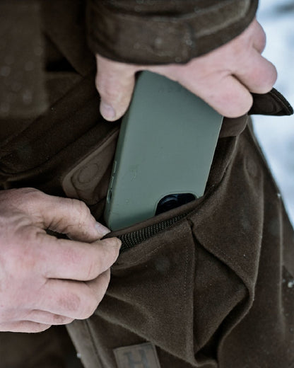 Dark Hunting Green Shadow Brown coloured Harkila Kodiak CleverWool HSP Insulated Trousers on winter background 