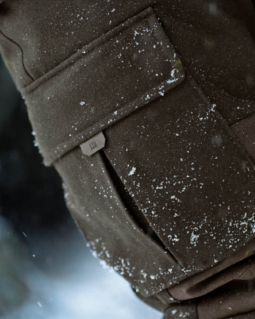 Dark Hunting Green Shadow Brown coloured Harkila Kodiak CleverWool HSP Insulated Trousers on winter background 