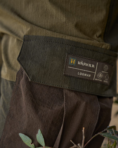 Dark Olive Willow Green Coloured Harkila Logmar Lightweight Zip Off Trousers on forest background 