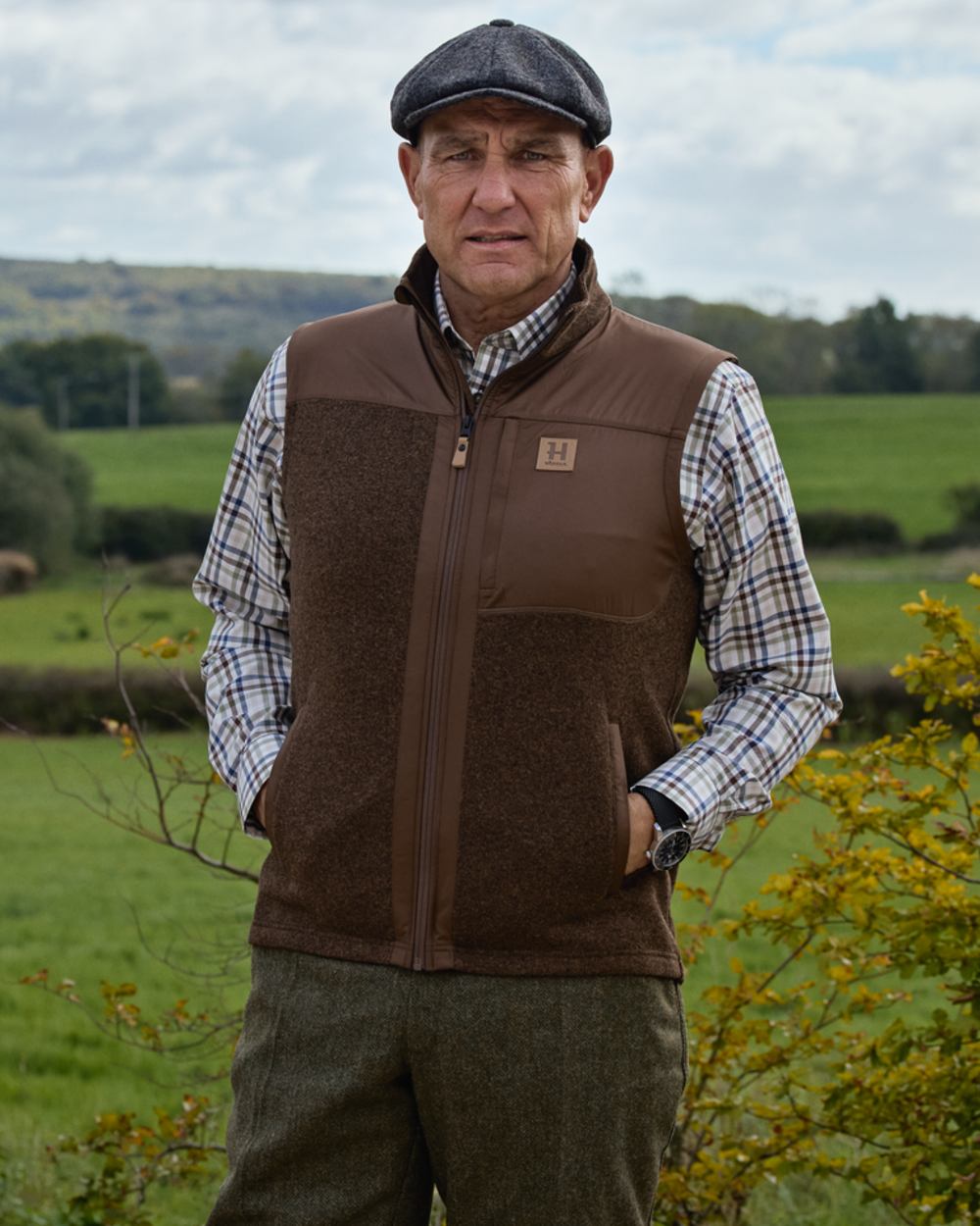 Dark Earth coloured Harkila Mens Kalix Fleece Waistcoat on outdoor background 