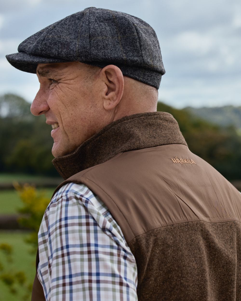 Dark Earth coloured Harkila Mens Kalix Fleece Waistcoat on outdoor background 