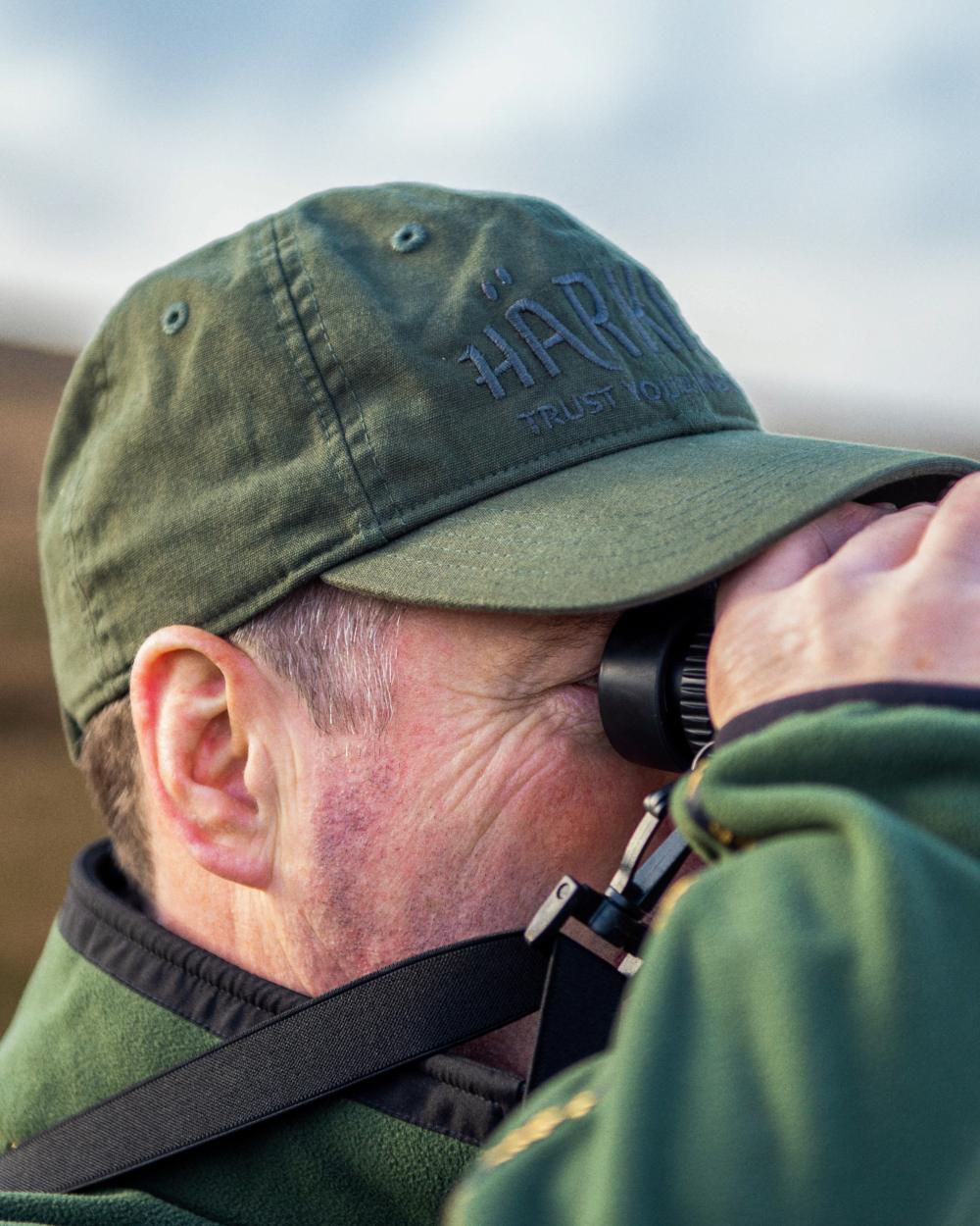 Duffel Green Coloured Harkila Modi Cap on sky background 
