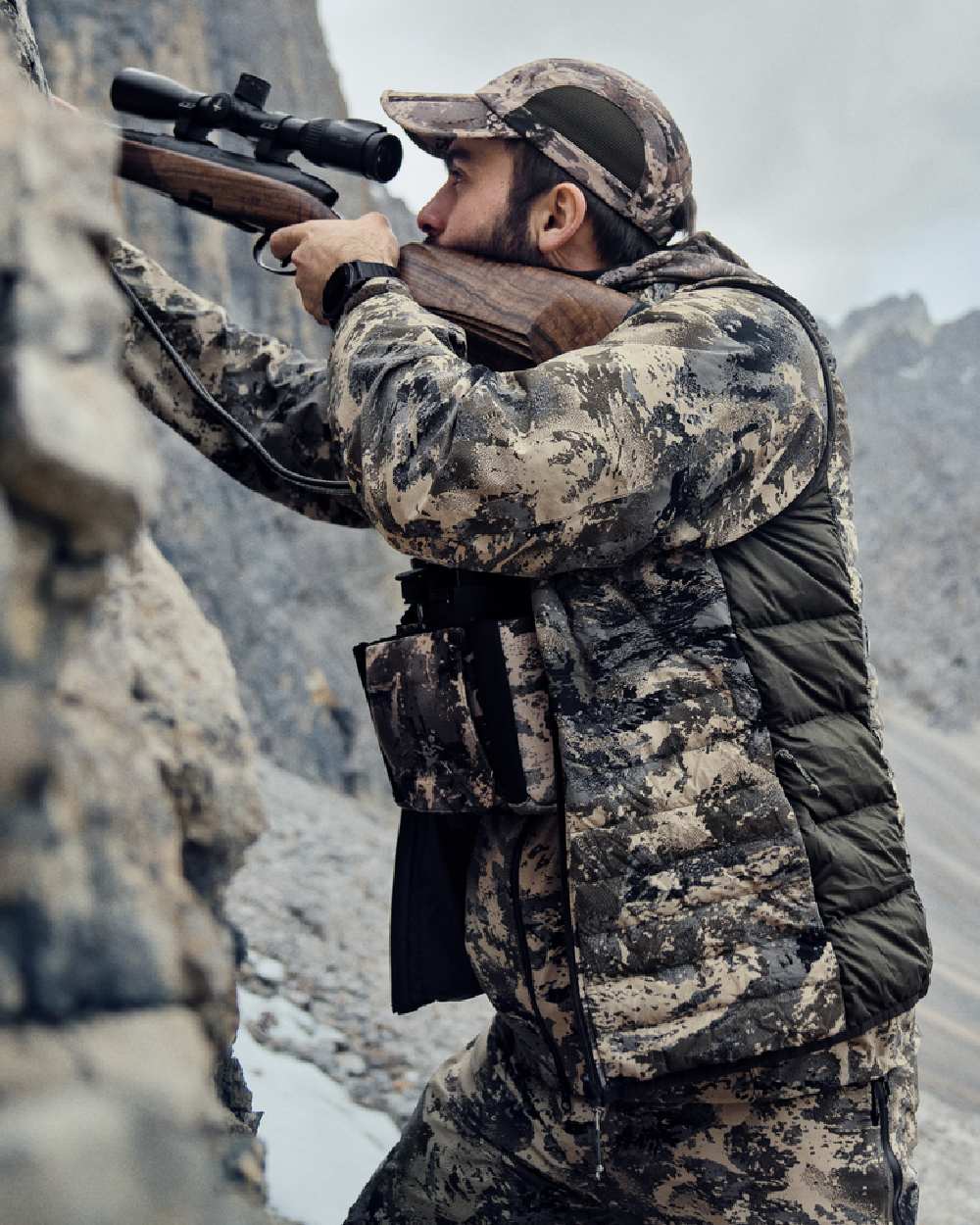 AXIS Mountain Shadow Brown Coloured Harkila Mountain Hunter Expedition Reversible Down Waistcoat on mountain background 