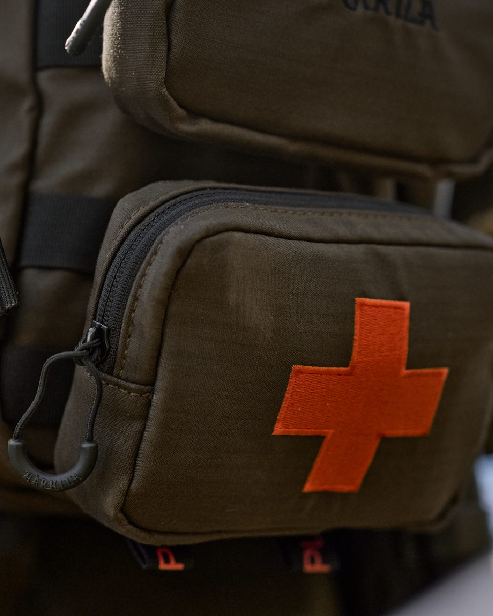 Willow Green Coloured Harkila Ragnar First Aid Backpack on blurry background 