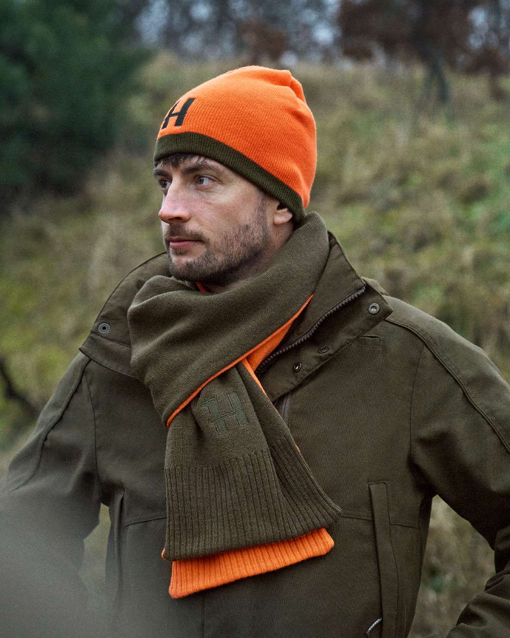 Willow Green Orange Coloured Harkila Reversible Beanie on outdoor background 