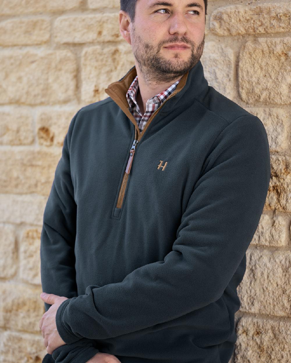 Dark Navy Coloured Harkila Sandhem 200 Fleece Pullover on wall background 