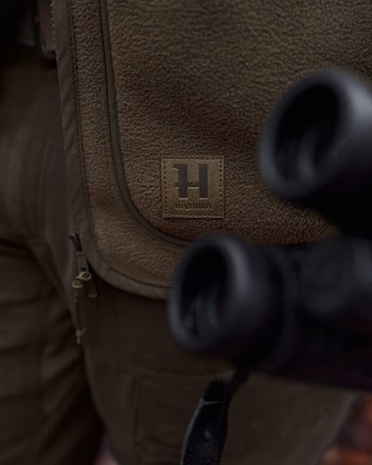 Dark Brown coloured Harkila Torsby Fleece Jacket on outdoor background 