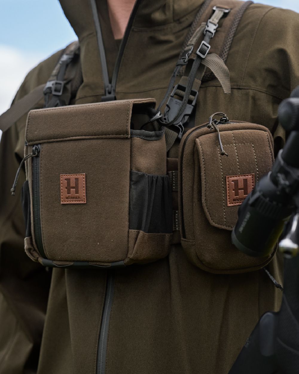 Dark Willow Green Coloured Harkila Utility Pouch on blurry background 