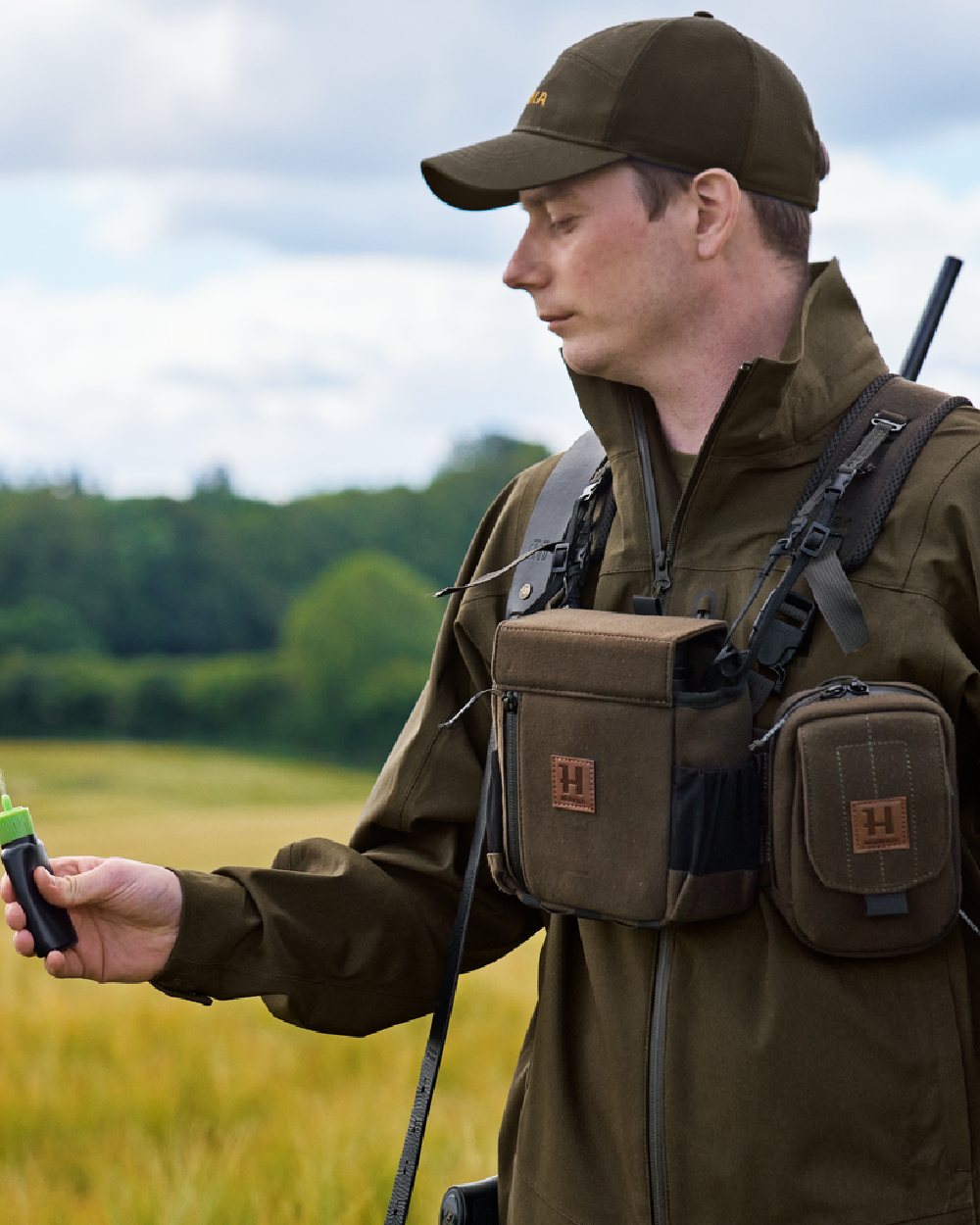 Dark Willow Green Coloured Harkila Utility Pouch on blurry background 