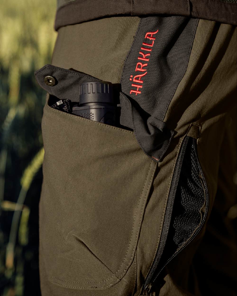 Willow Green Coloured Harkila Wildboar Pro Move Trousers on outdoor background 