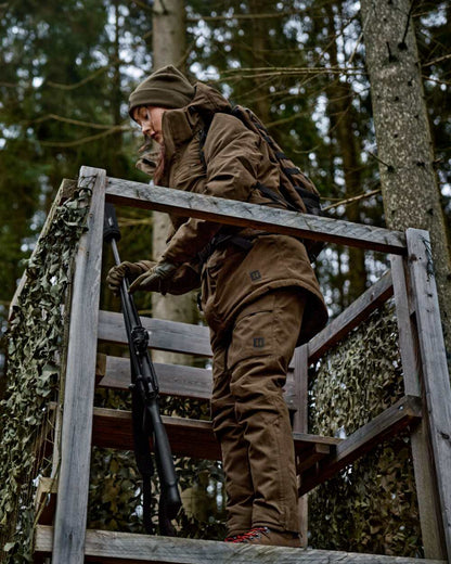 Willow Green Coloured Harkila Womens Driven Hunt HWS Insulated Trousers on forest background 