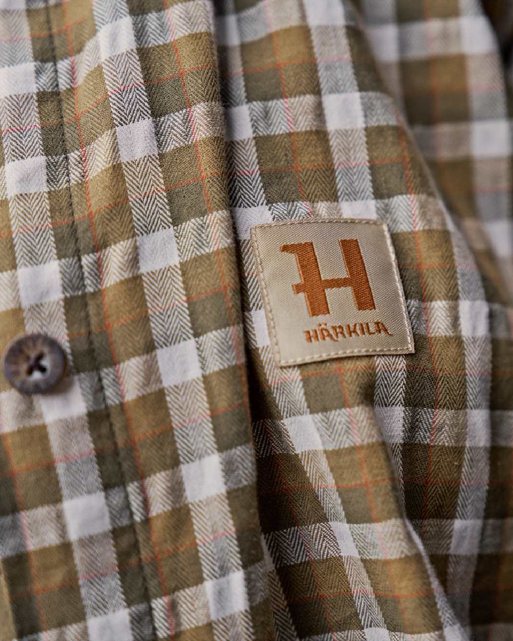 Dark Olive Check Coloured Harkila Womens Fjell Long Sleeve Shirt on blurry background 