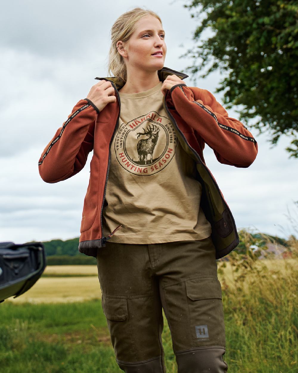 Dark Olive Arabian Spice Coloured Harkila Womens Kamko Reversible Windstopper Fleece Jacket on outdoor background 