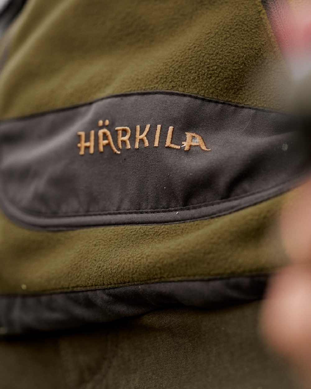 Dark Olive Arabian Spice Coloured Harkila Womens Kamko Reversible Windstopper Fleece Jacket on outdoor background 