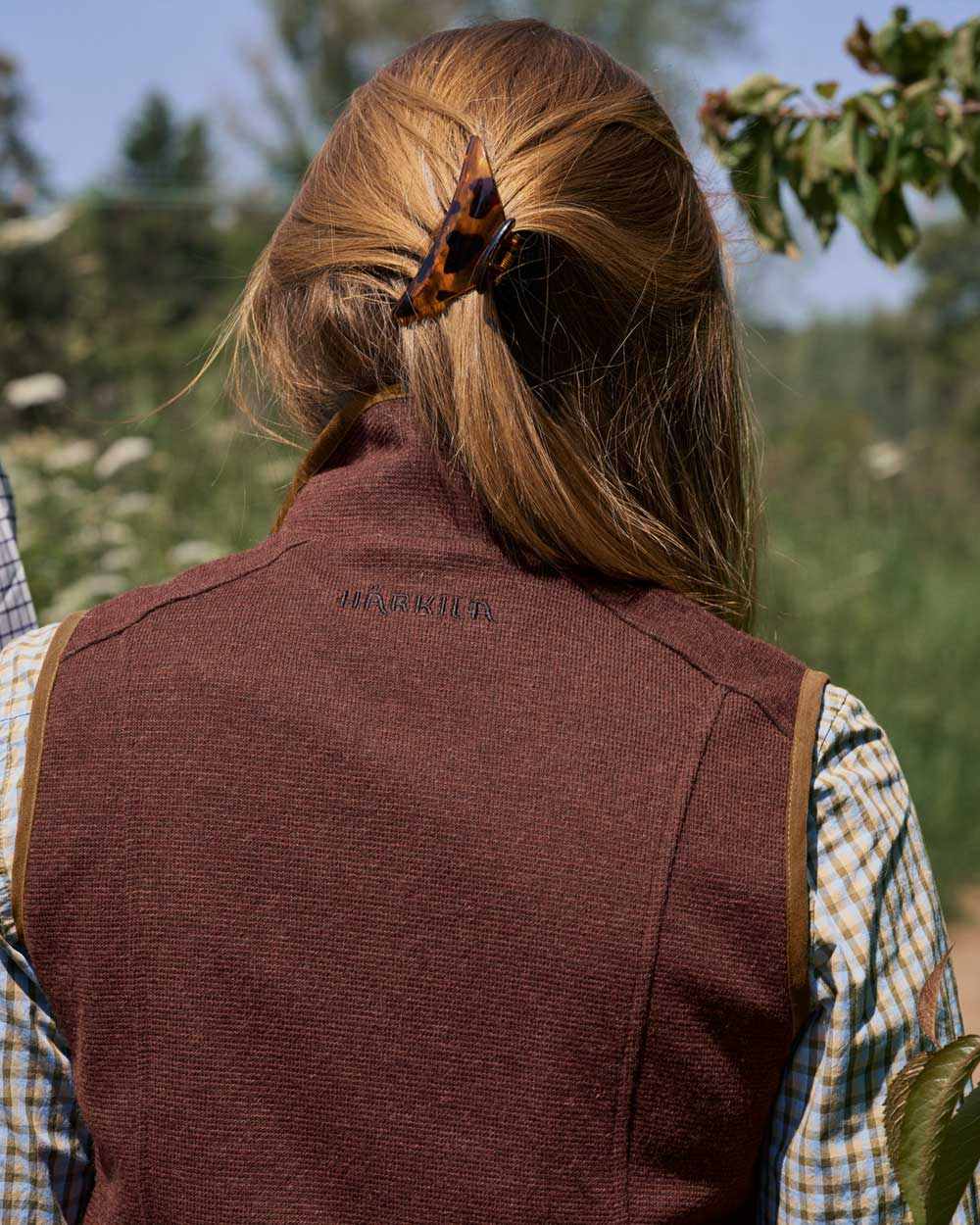 Dark Copper Coloured Harkila Womens Sandhem Pro Waistcoat on outdoor background 