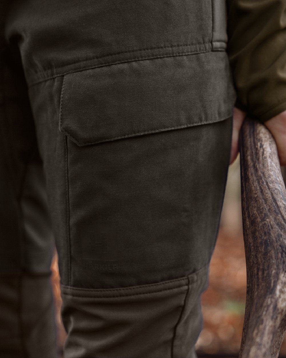 Shadow Brown Deep Brown coloured Harkila Womens Scandinavian Trousers on woodland background 