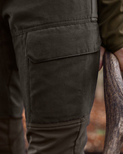 Shadow Brown Deep Brown coloured Harkila Womens Scandinavian Trousers on woodland background 