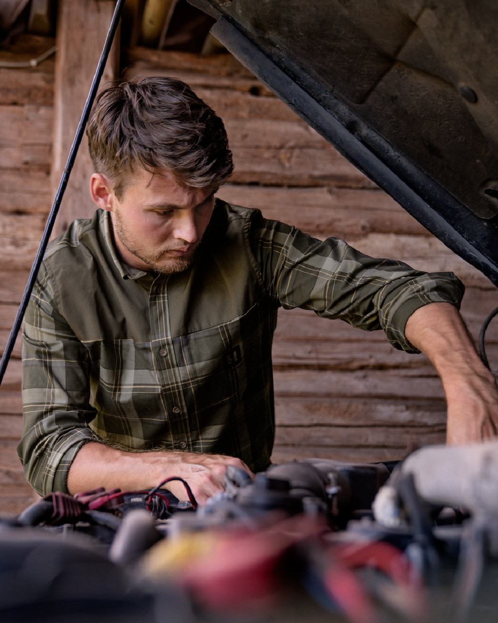 Willow Green coloured Harkila Anker Long Sleeve Shirt worn by man working on an engine in a farm