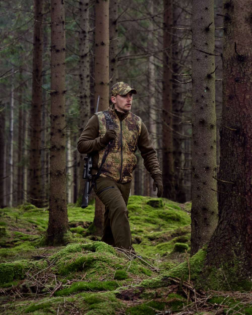 AXIS Forest coloured Harkila Deer Stalker Camo Reversible Packable Waistcoat worn by hunter in woodland