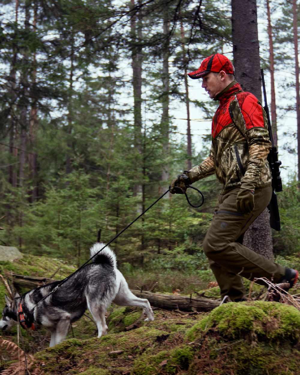 Hunting Green/Mossy Oak Break-up Country coloured Harkila Kamko Camo Reversible WSP Jacket worn by dogwalker in forest