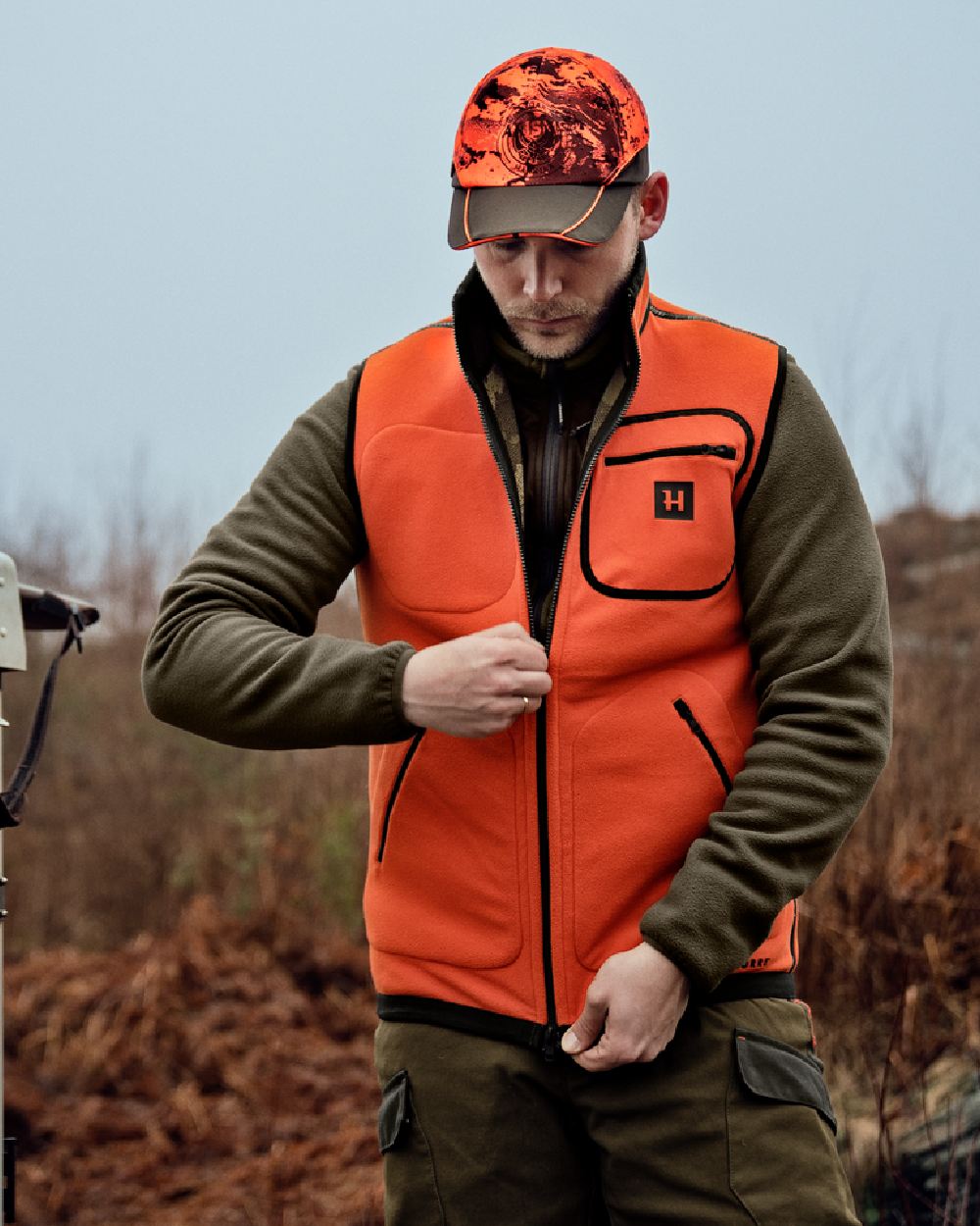 AXIS Limited Edition Orange coloured Harkila Kamko Pro Edition Reversible Hi-Vis Waistcoat on woodland background