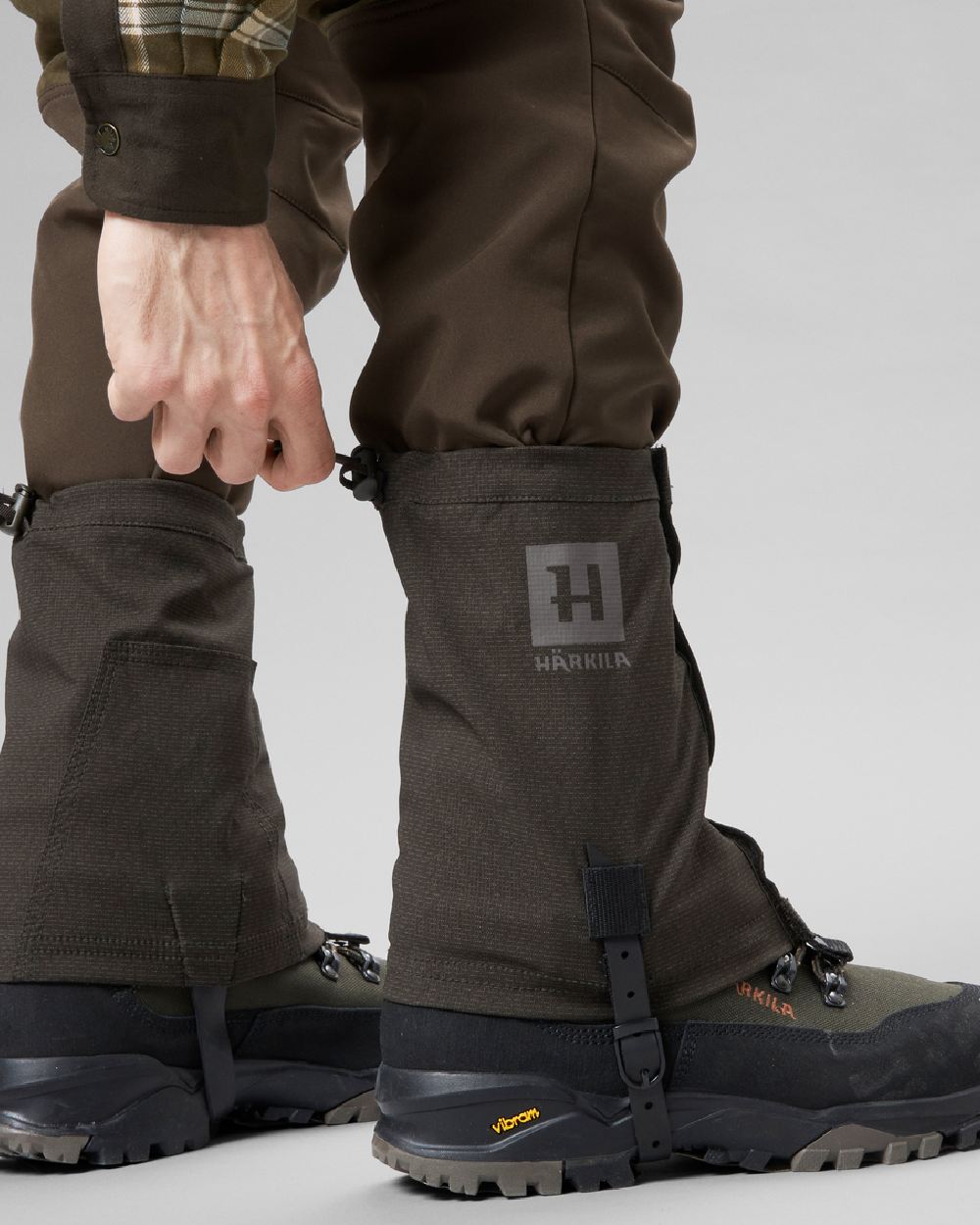 Shadow Brown coloured Harkila Ledge Gaiters on grey background