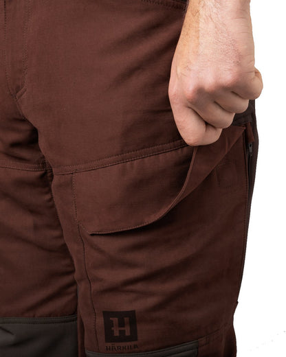 Bloodstone Red/Shadow Brown coloured Harkila Scandinavian Trousers pocket close up on white background 