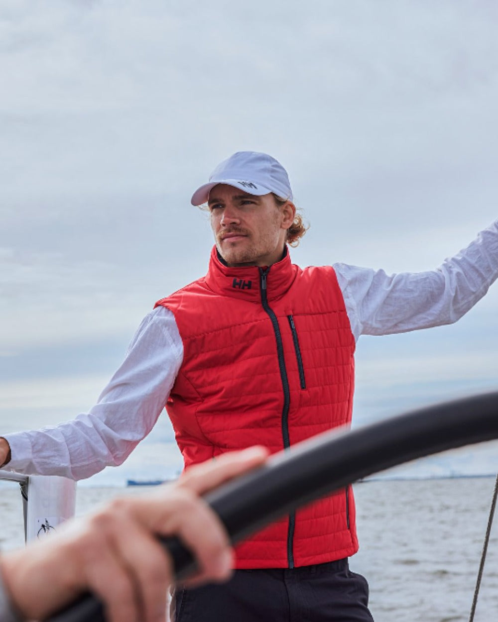 White coloured Helly Hansen Crew Cap 2.0 on sea background 