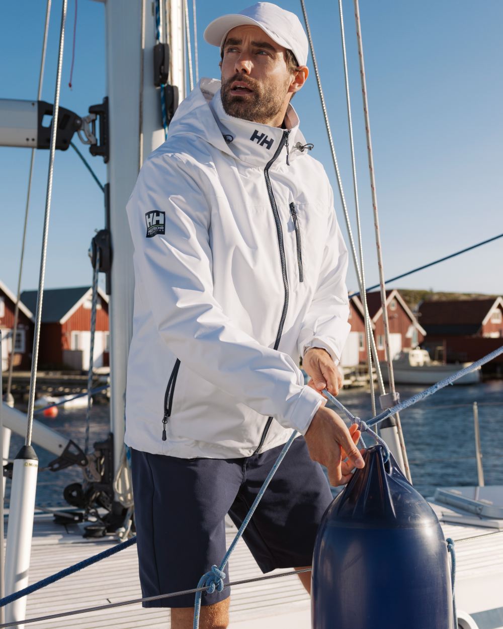 White coloured Helly Hansen Mens Crew Hooded Midlayer Jacket on sea background 