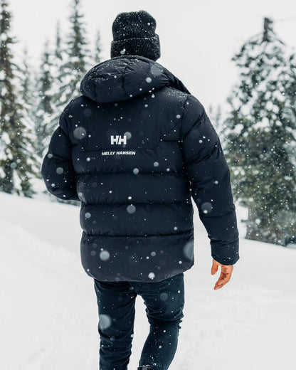 Black Coloured Helly Hansen Mens Explorer Puffy Jacket on snow background 