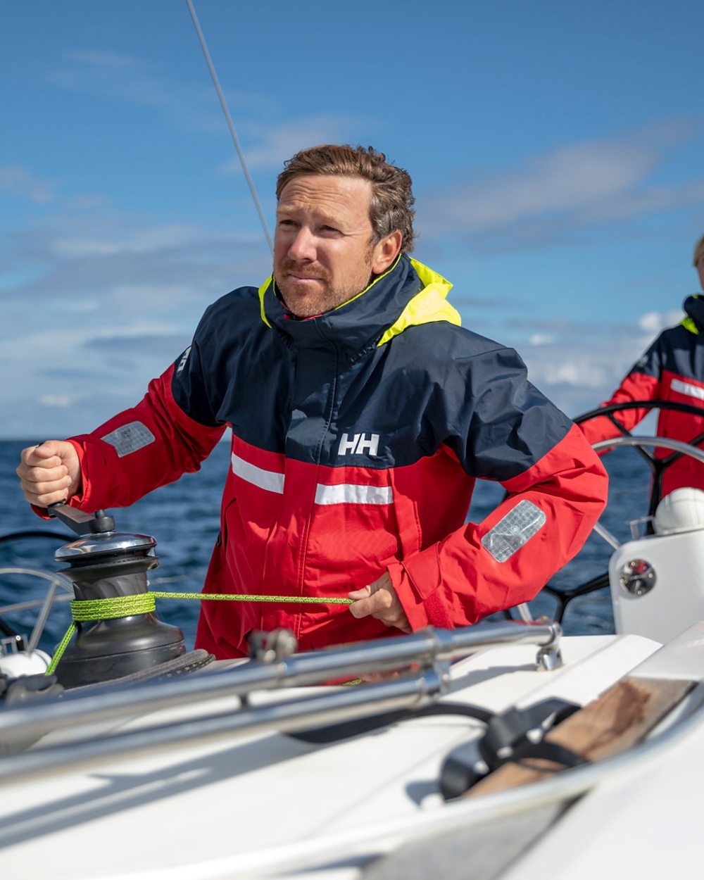Red coloured Helly Hansen Mens Pier 4.0 Jacket on blurry background 
