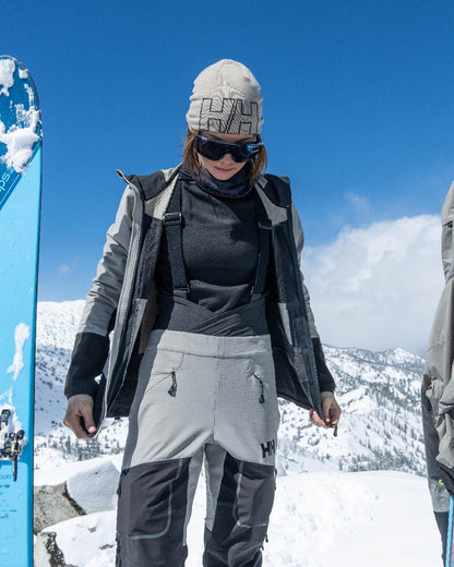 White Coloured Helly Hansen Outline Beanie on snow background 