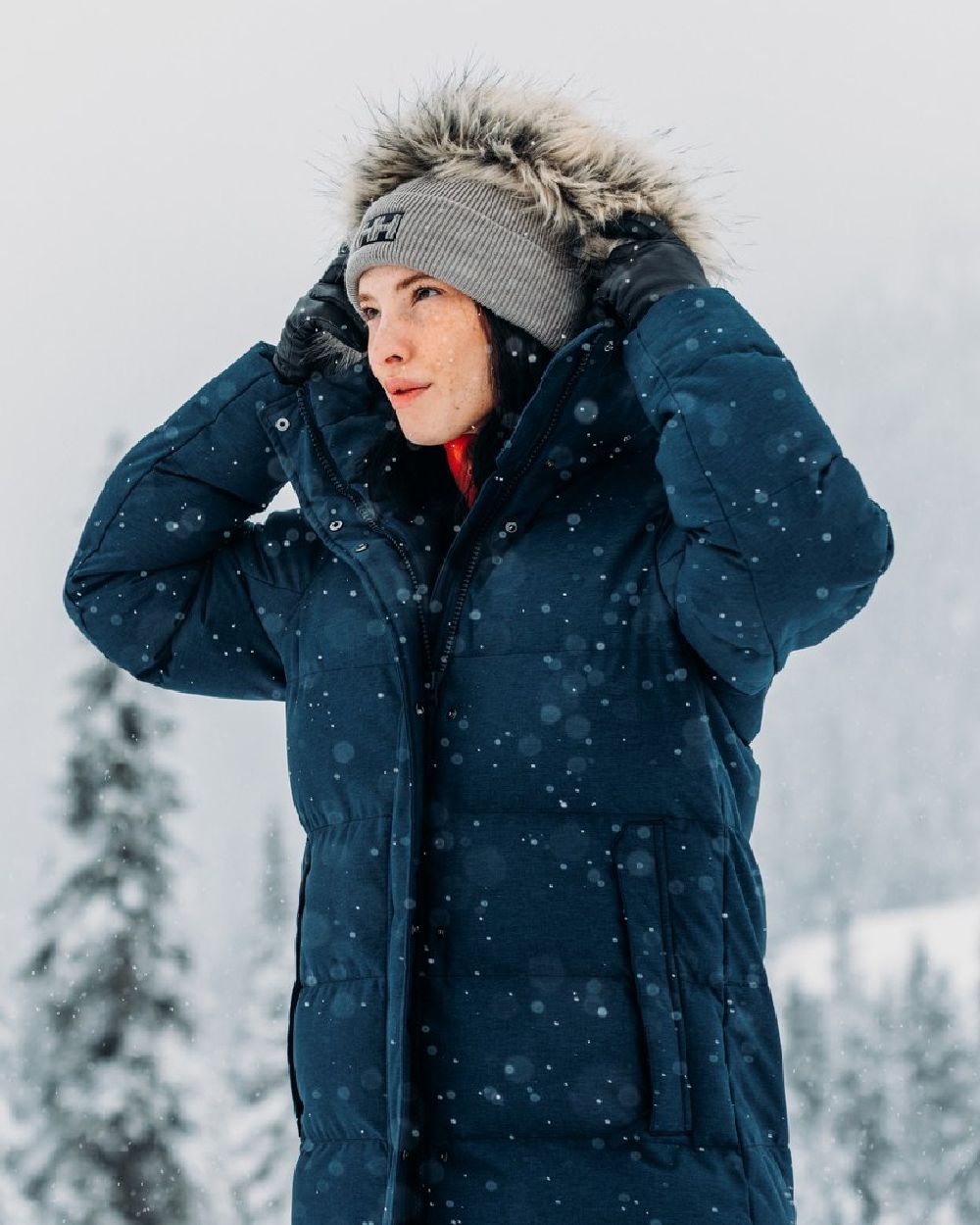 Woman wearing a Helly Hansen parka in falling snow