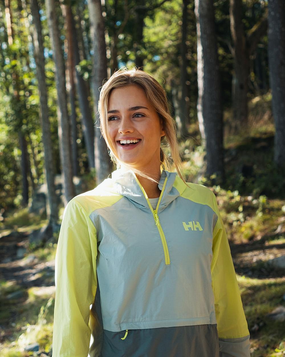Sharp Green coloured Helly Hansen Womens Roam Wind Anorak on forest background 