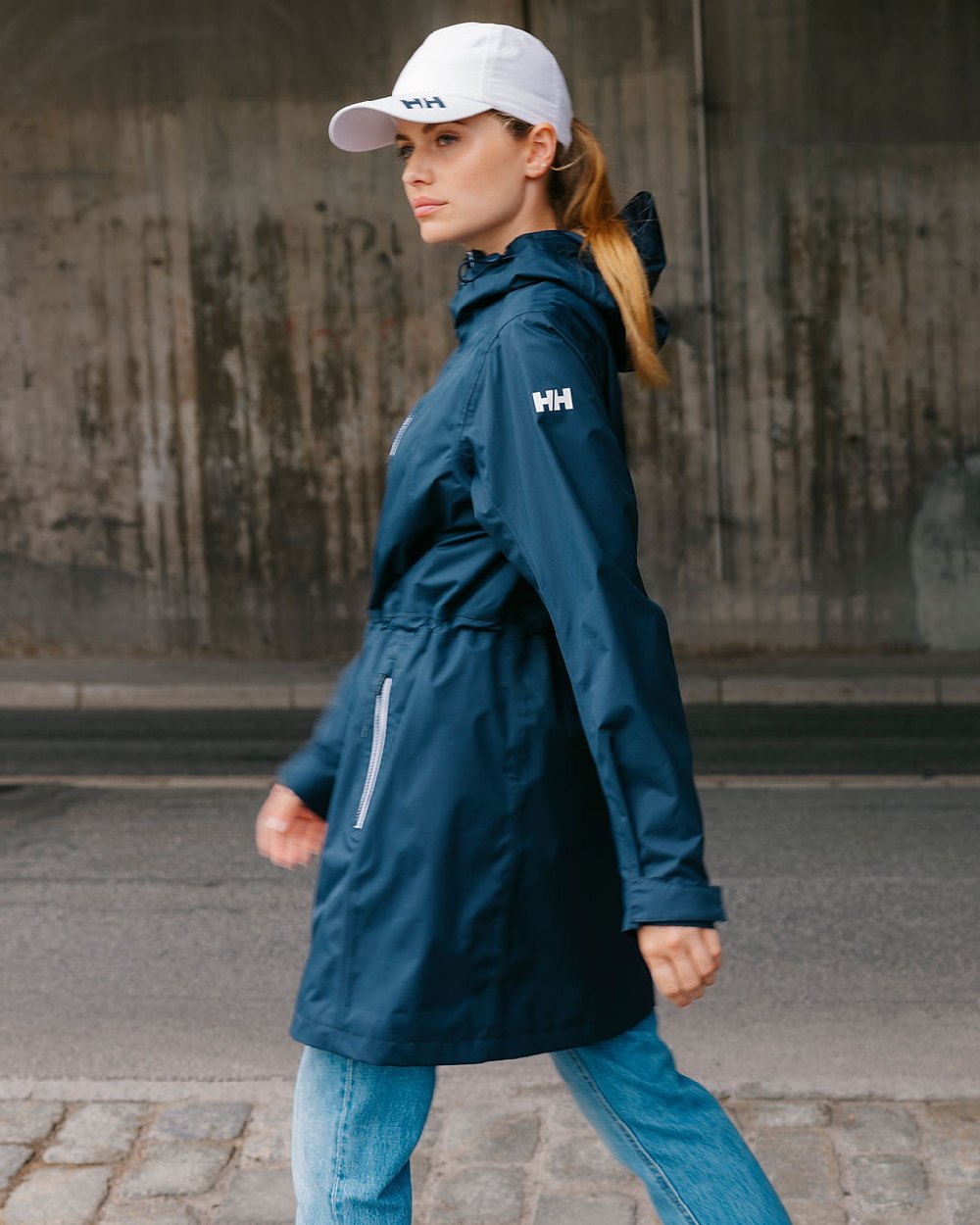 Navy coloured Helly Hansen Womens Westport Raincoat on street background 