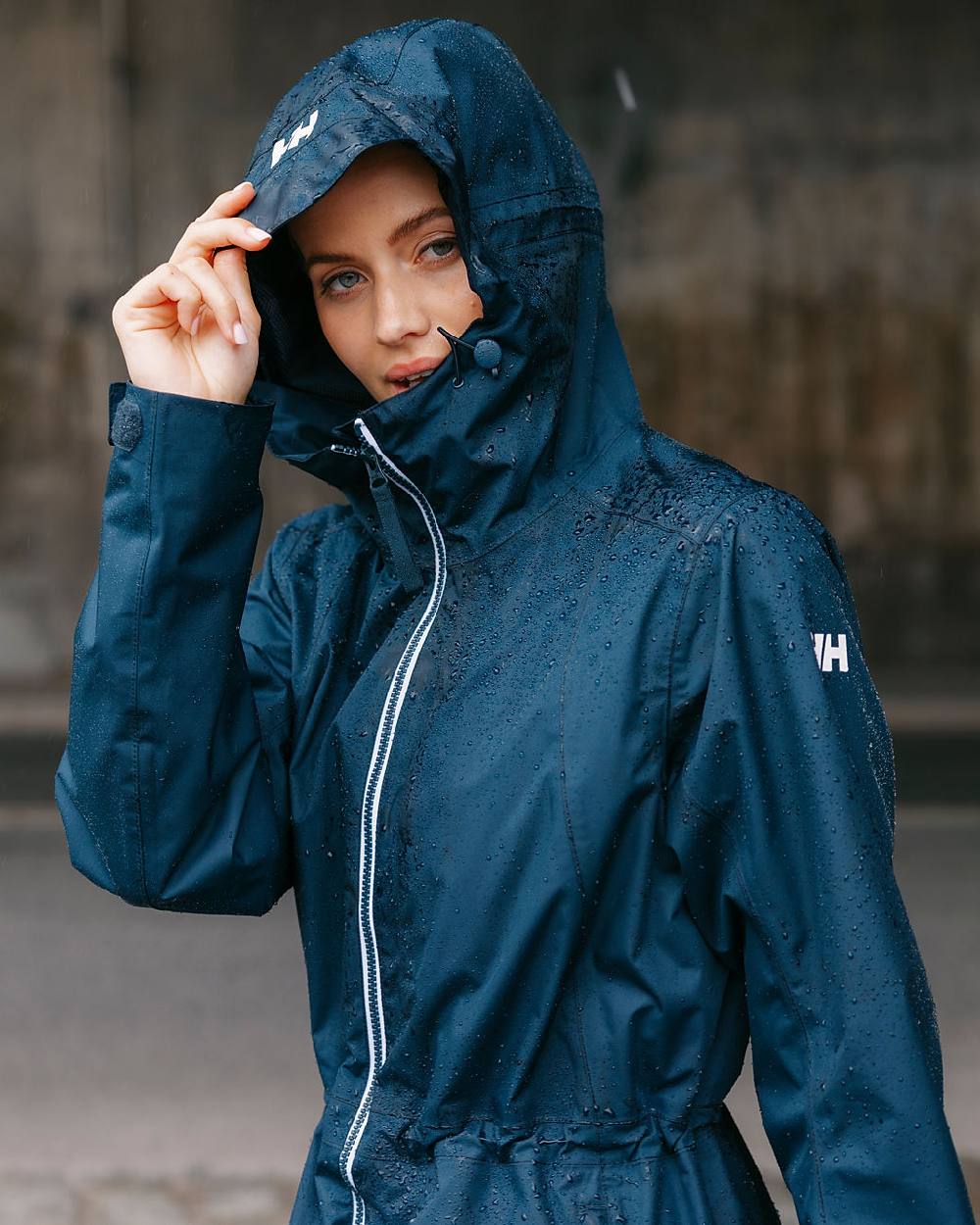 Navy coloured Helly Hansen Womens Westport Raincoat on street background 