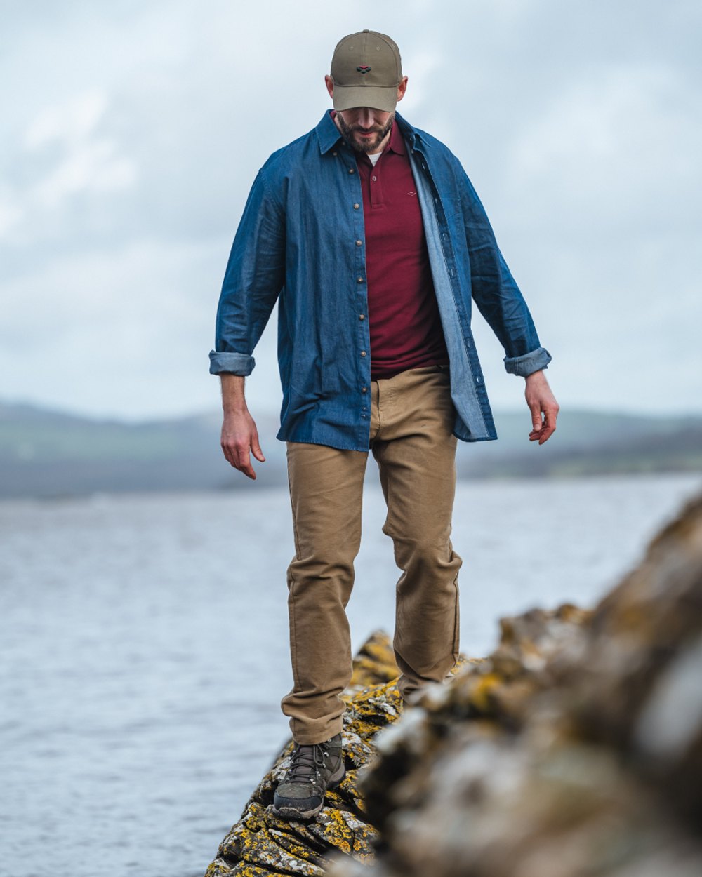 Dark wash coloured Hoggs of Fife Archerfield Denim Shirt on model with beach background  