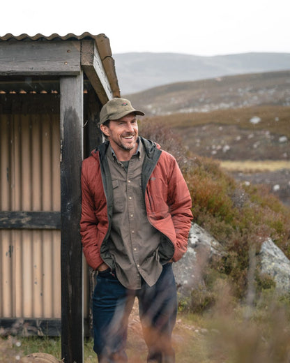 Olive coloured Hoggs of Fife Mens Aviemore Reversible Insulated Jacket on moorland background 