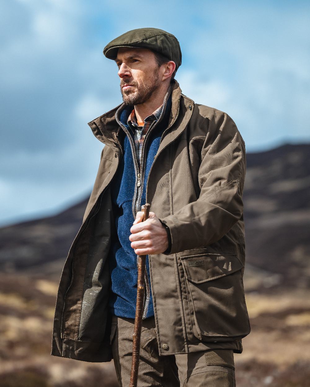 Green Coloured Hoggs of Fife Ballater Waterproof Field Jacket on blurry background 